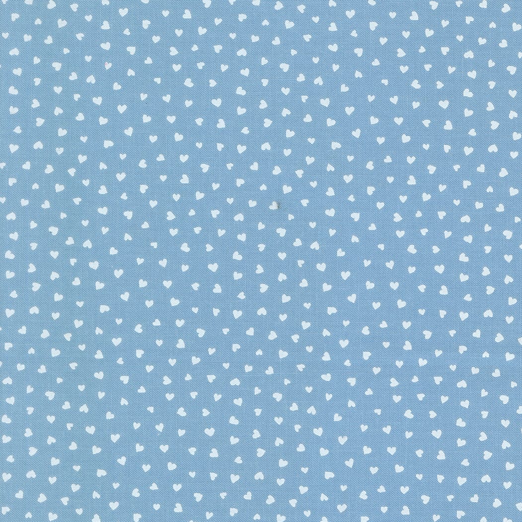 A closeup shot of the quilting fabric pattern called Tiny Hearts, designed by Lizzy House, in the sky colorway. The SKU is 37148 25.