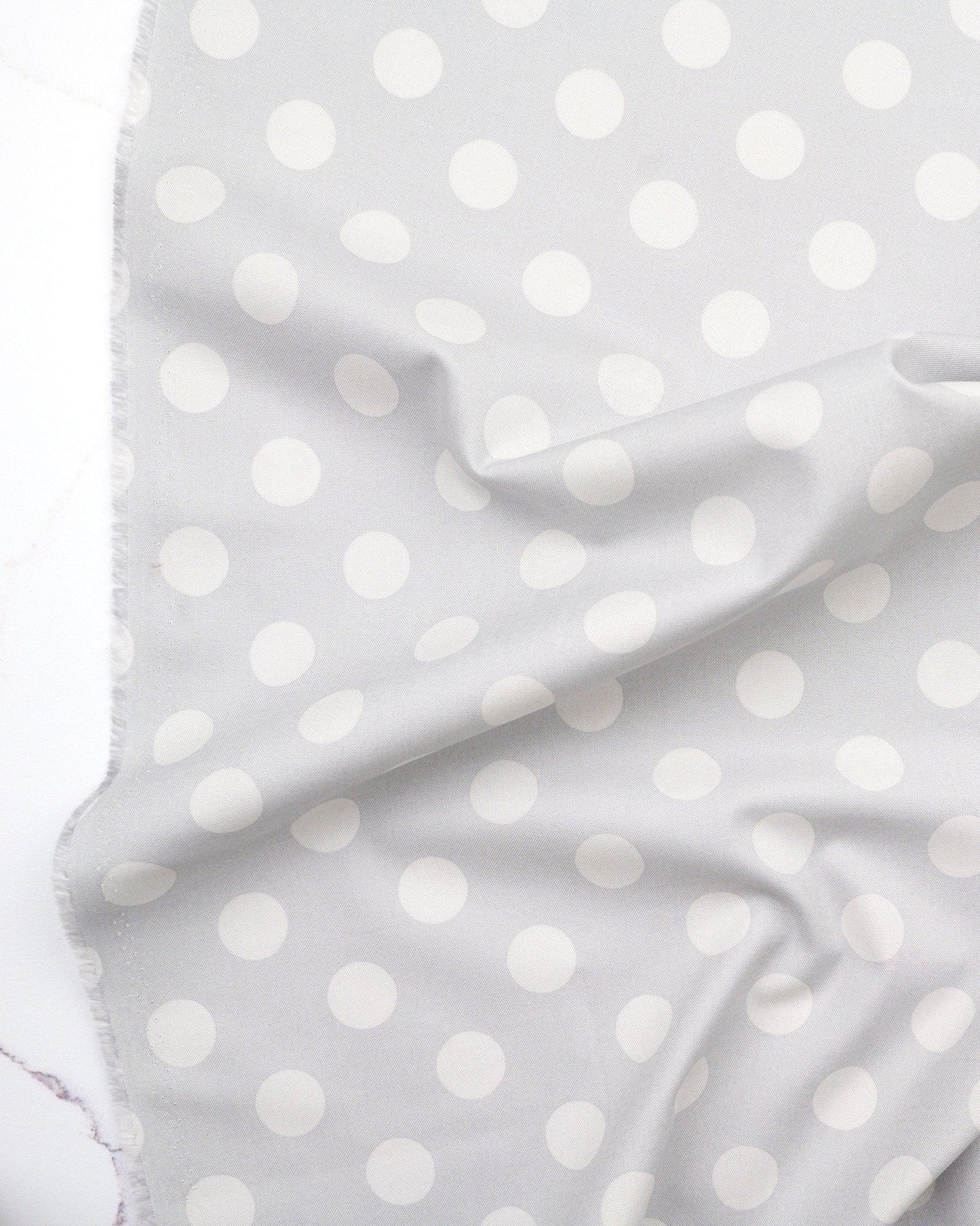 Pom Poms in Fog quilting fabric, part of the Fall 2025 True Colors fabric collection by Tula Pink (SKU: PWTP118.FOG)