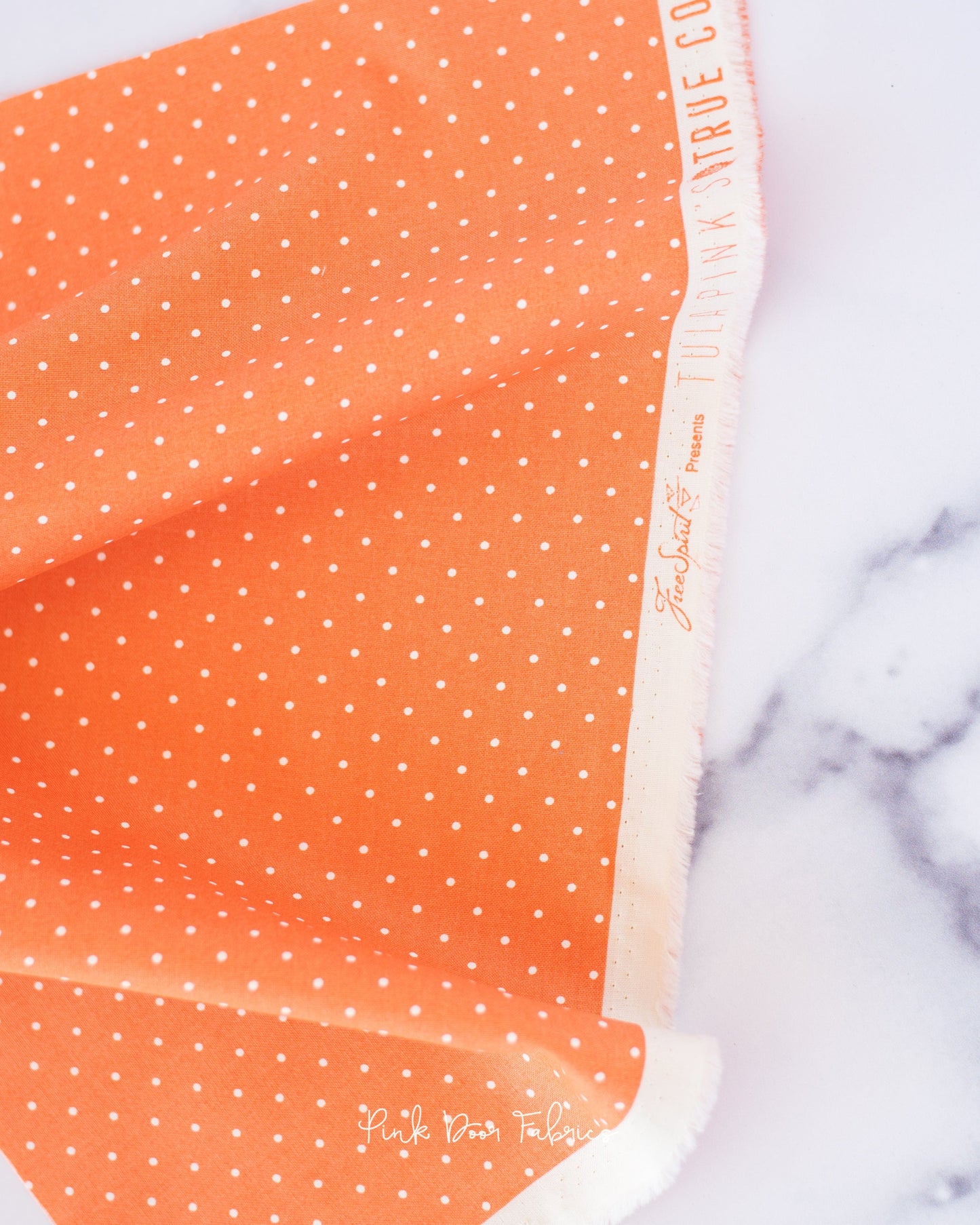 Cotton quilting fabric pattern called 'Tiny Dots in Peachy'. Part of the 'True Colors' fabric collection. Designed by Tula Pink for fabric company Free Spirit Fabrics. SKU: PWTP185.PEACHY. 44-45 inch width.