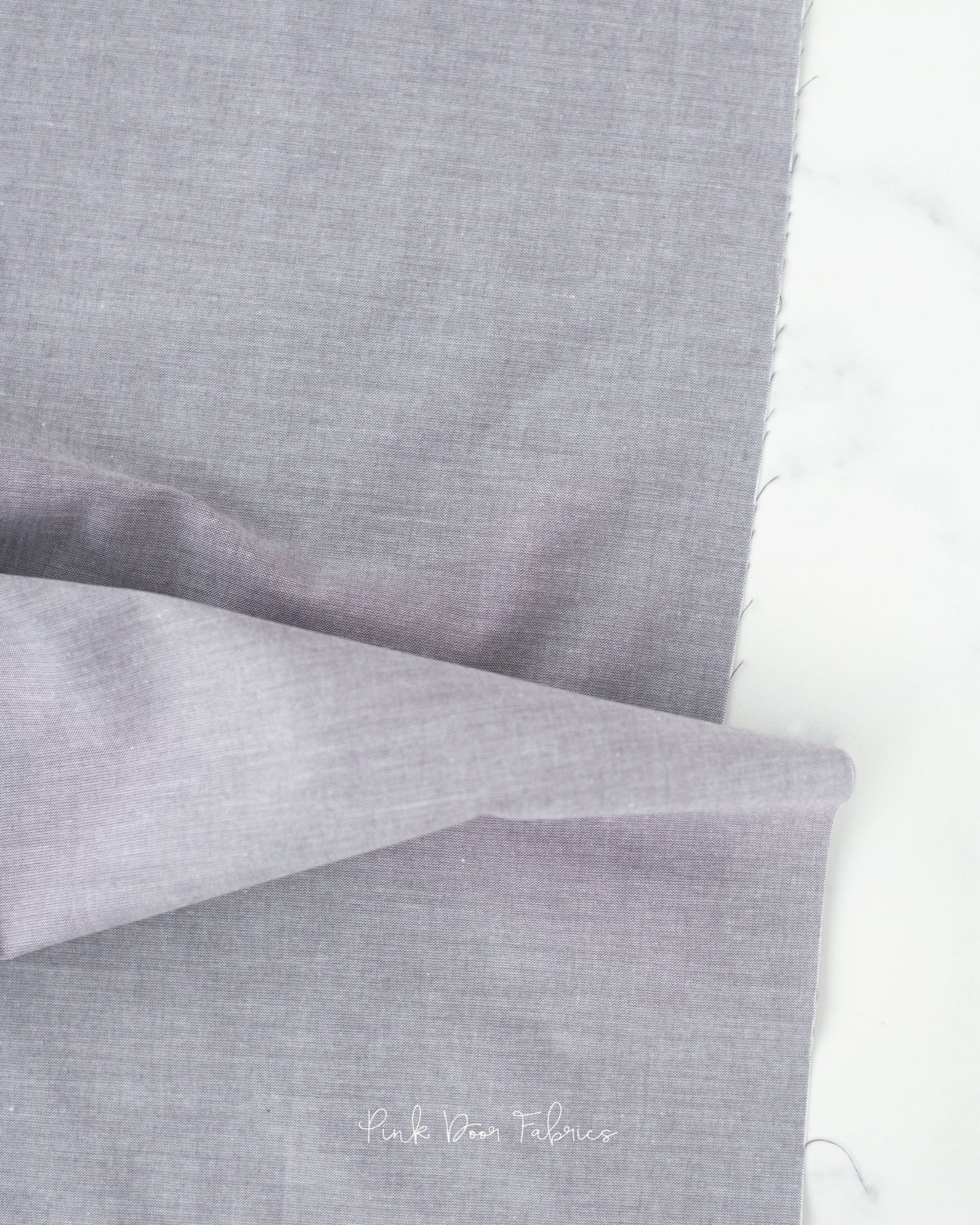 Chambray quilting fabric pattern called 'Grey'. Part of the 'Chambray Solids' fabric collection. Designed by Tilda Fabrics for the Tilda Fabrics fabric company. SKU: 160006. 44-45 inch width.