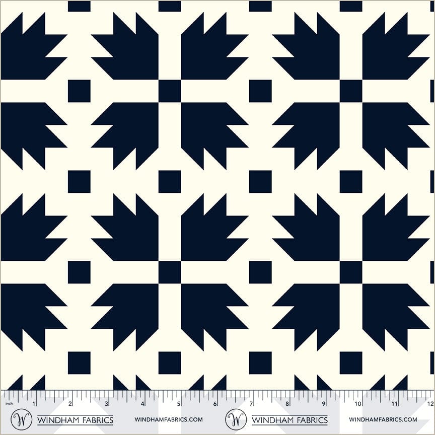 A closeup shot of the quilting fabric pattern called Bear Paw, designed by Whistler Studios, in the navy colorway. The SKU is 54879-2.