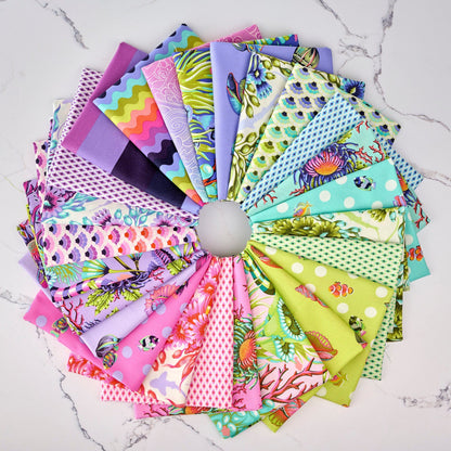 Collection of colorful Floral Reef fabric swatches arranged in a circular pattern on a marble surface, designed by Tula Pink