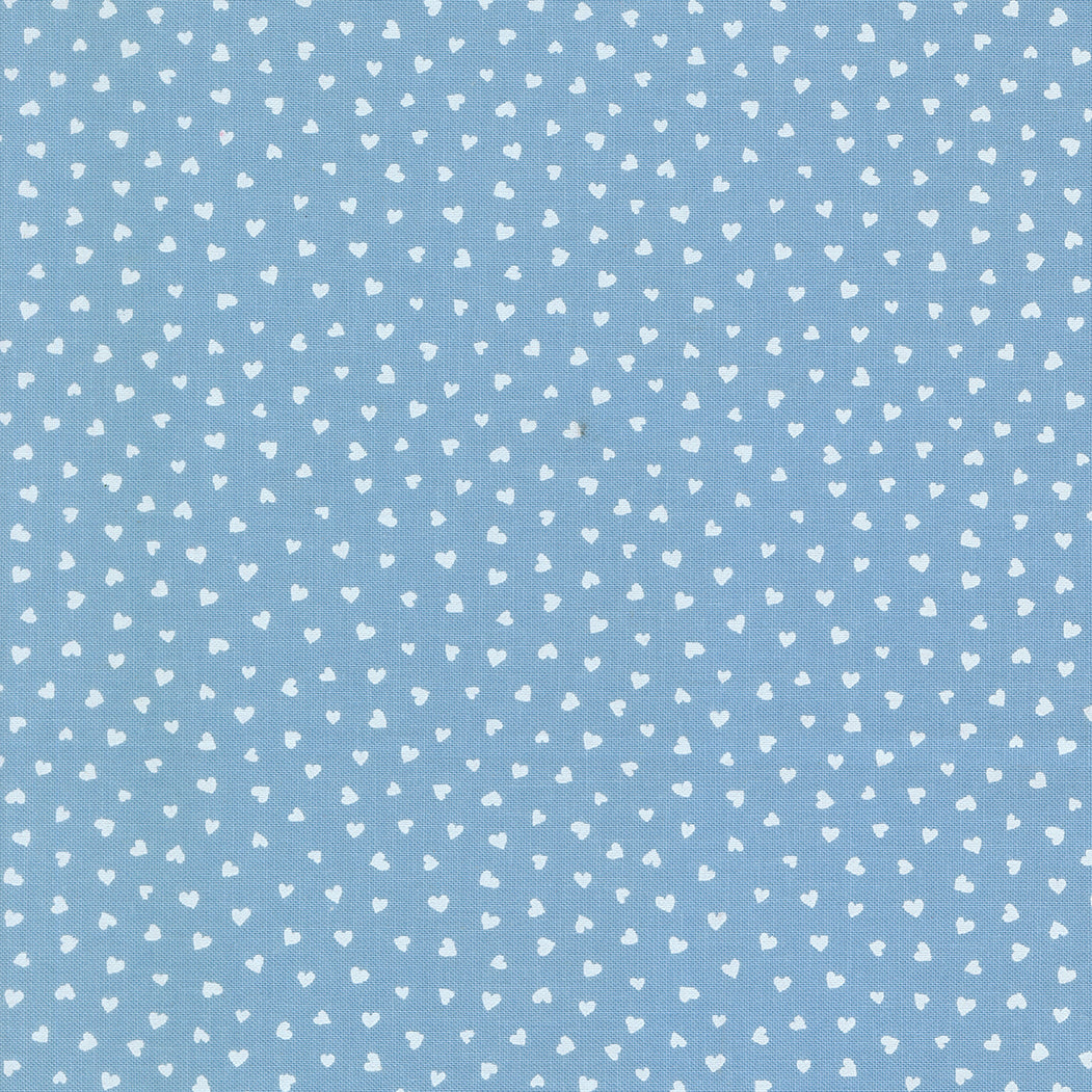 A closeup shot of the quilting fabric pattern called Tiny Hearts, designed by Lizzy House, in the sky colorway. The SKU is 37148 25.