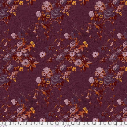 A piece of fabric featuring a floral pattern with shades of purple, pink, and orange on a red background.