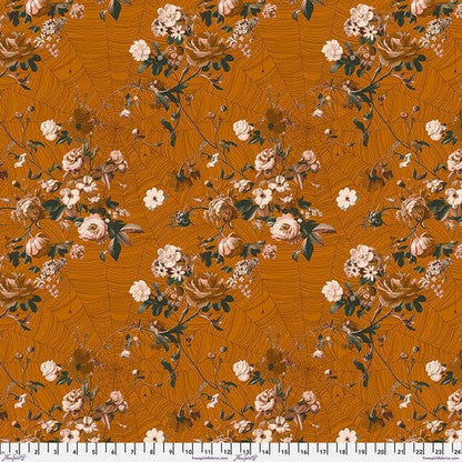 A piece of burnt orange/gold spice colored fabric with a floral pattern designed by Giucy Giuce for Free Spirit Fabrics, part of the Enrapture collection.