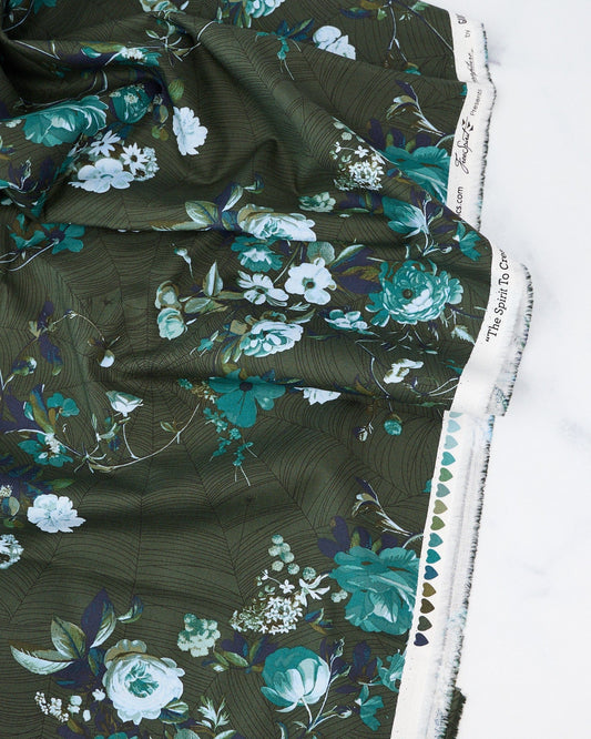 A piece of verdant green fabric with a floral pattern designed by Giucy Giuce for Free Spirit Fabrics, part of the Enrapture collection.