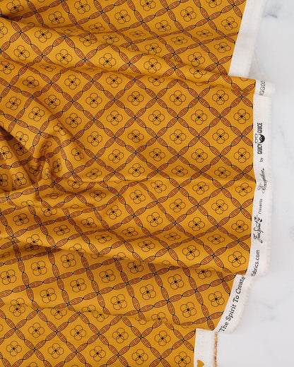 A swatch of fabric featuring a geometric tile pattern in various shades of orange and brown.