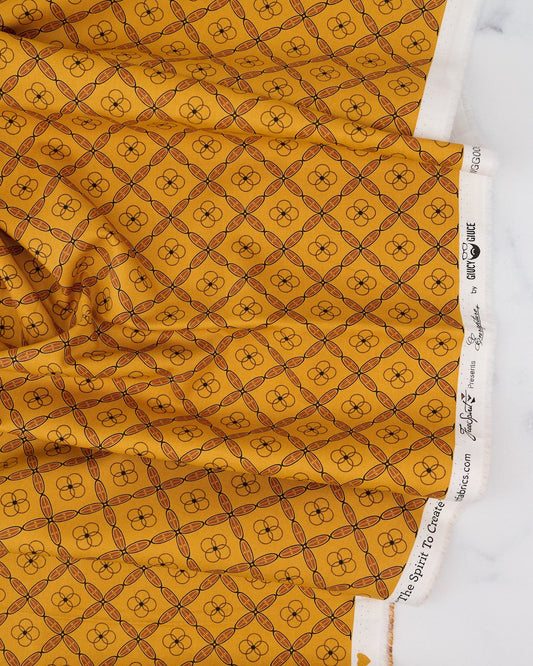 A swatch of fabric featuring a geometric tile pattern in various shades of orange and brown.