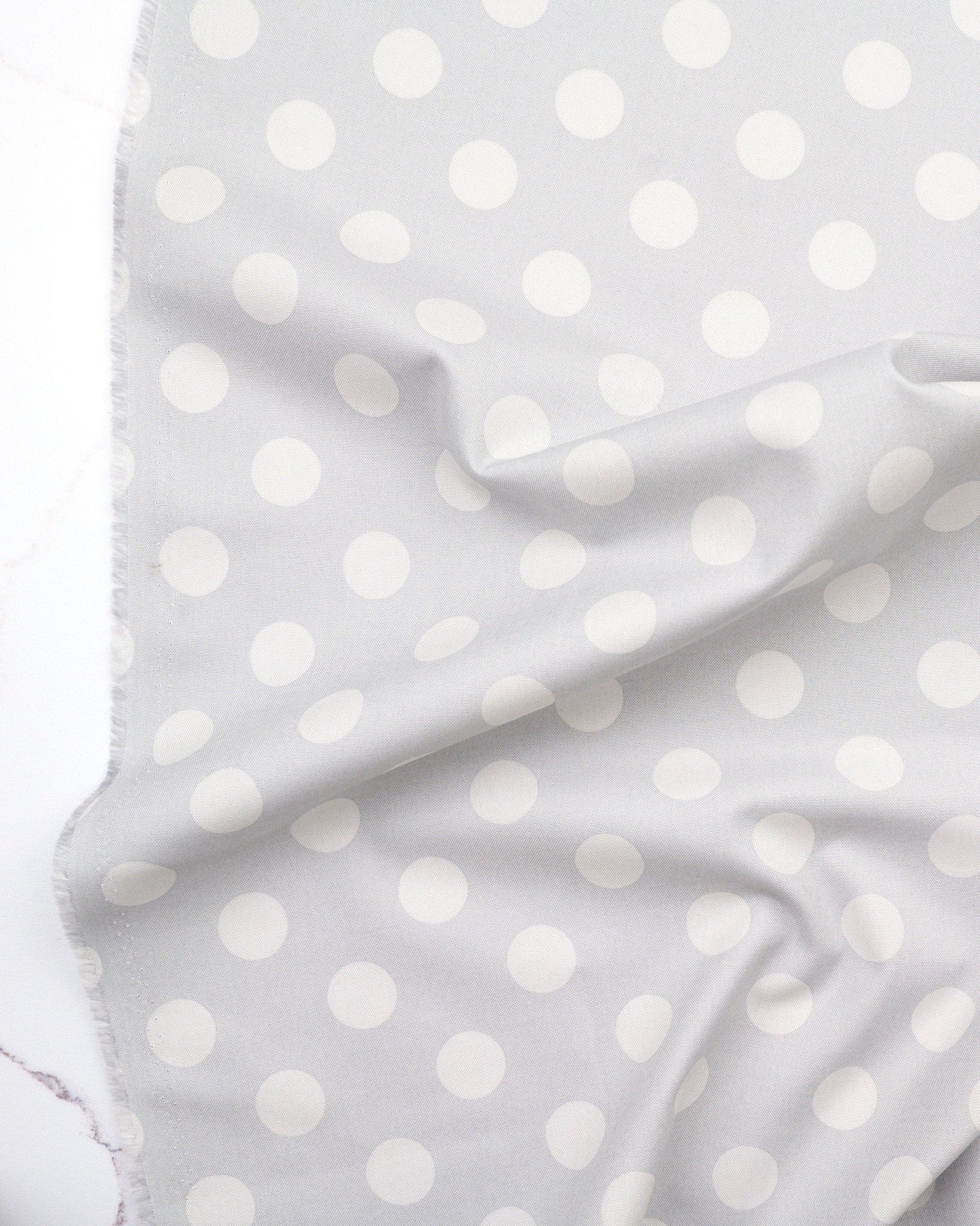 Pom Poms in Fog quilting fabric, part of the Fall 2025 True Colors fabric collection by Tula Pink (SKU: PWTP118.FOG)