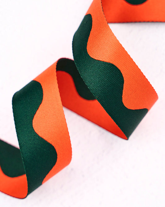 Close up of orange and green two-tone nylon wavy pattern webbing for bag making, straps and accessories, by Renaissance Ribbons