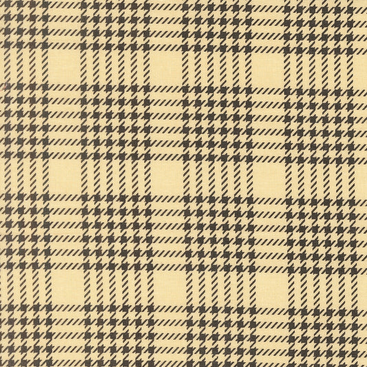Moda's ghost plaid cotton quilting fabric features dark gray houndstooth patterns on a pale yellow background. Gothic Haunt by Stacy Iest Hsu.