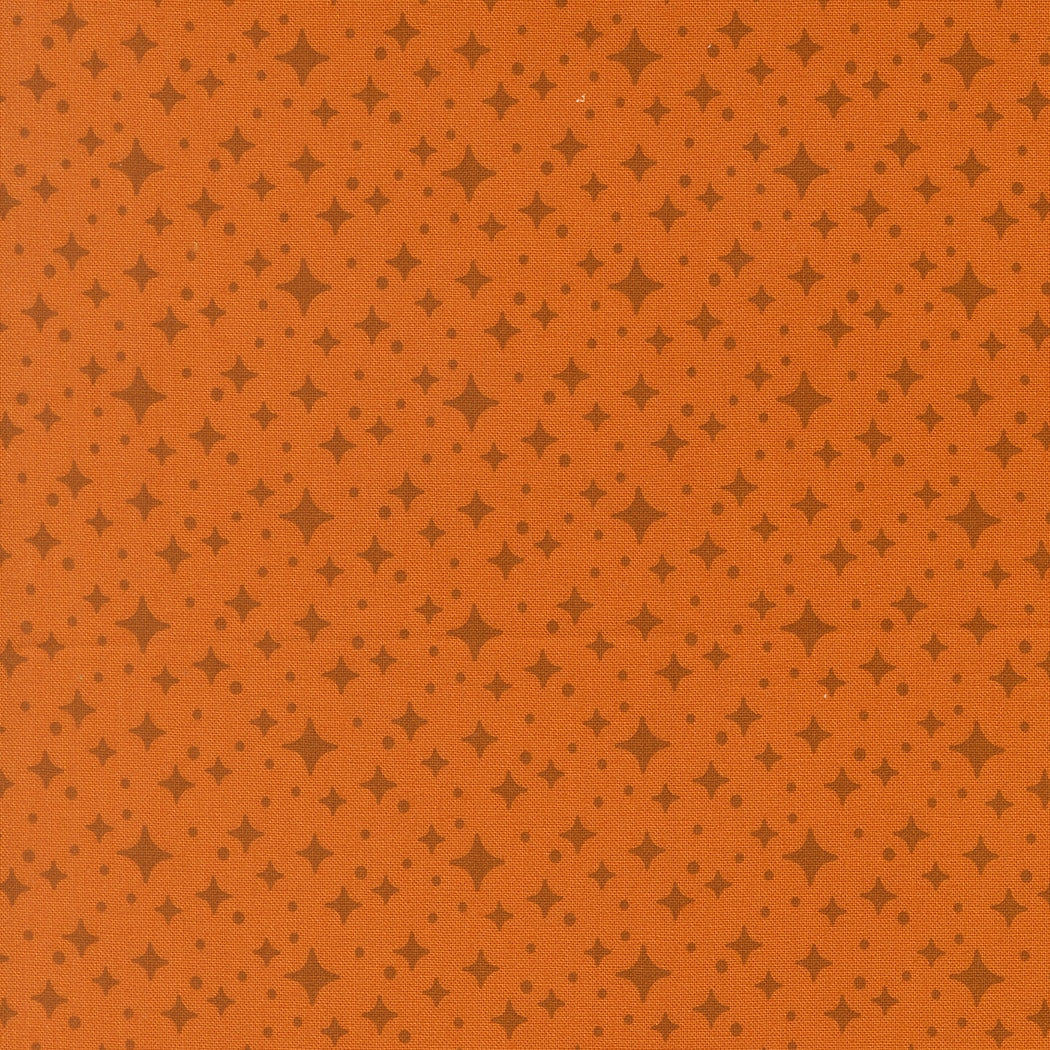 Moda's Popcorn by Elizabeth Hartman cotton quilting fabric. Rust orange ground with small dark brown four-point stars and tiny dots.