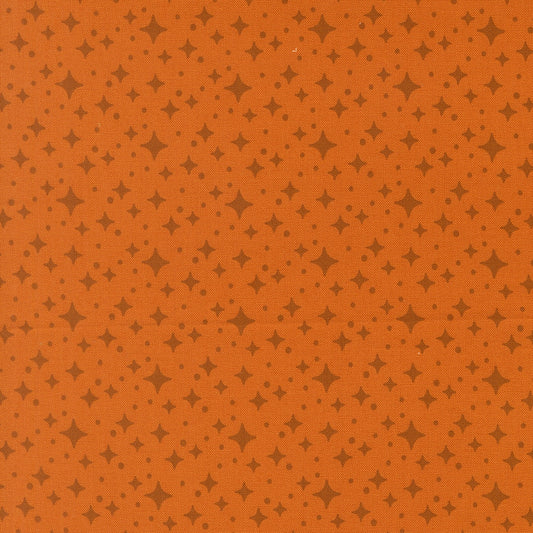 Moda's Popcorn by Elizabeth Hartman cotton quilting fabric. Rust orange ground with small dark brown four-point stars and tiny dots.