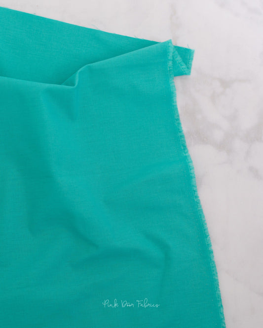 Cotton quilting fabric pattern called 'Solid in Aegean'. Part of the 'True Colors' fabric collection. Designed by Tula Pink for fabric company Free Spirit Fabrics. SKU: CSFSESS.AEGEAN. 44-45 inch width.