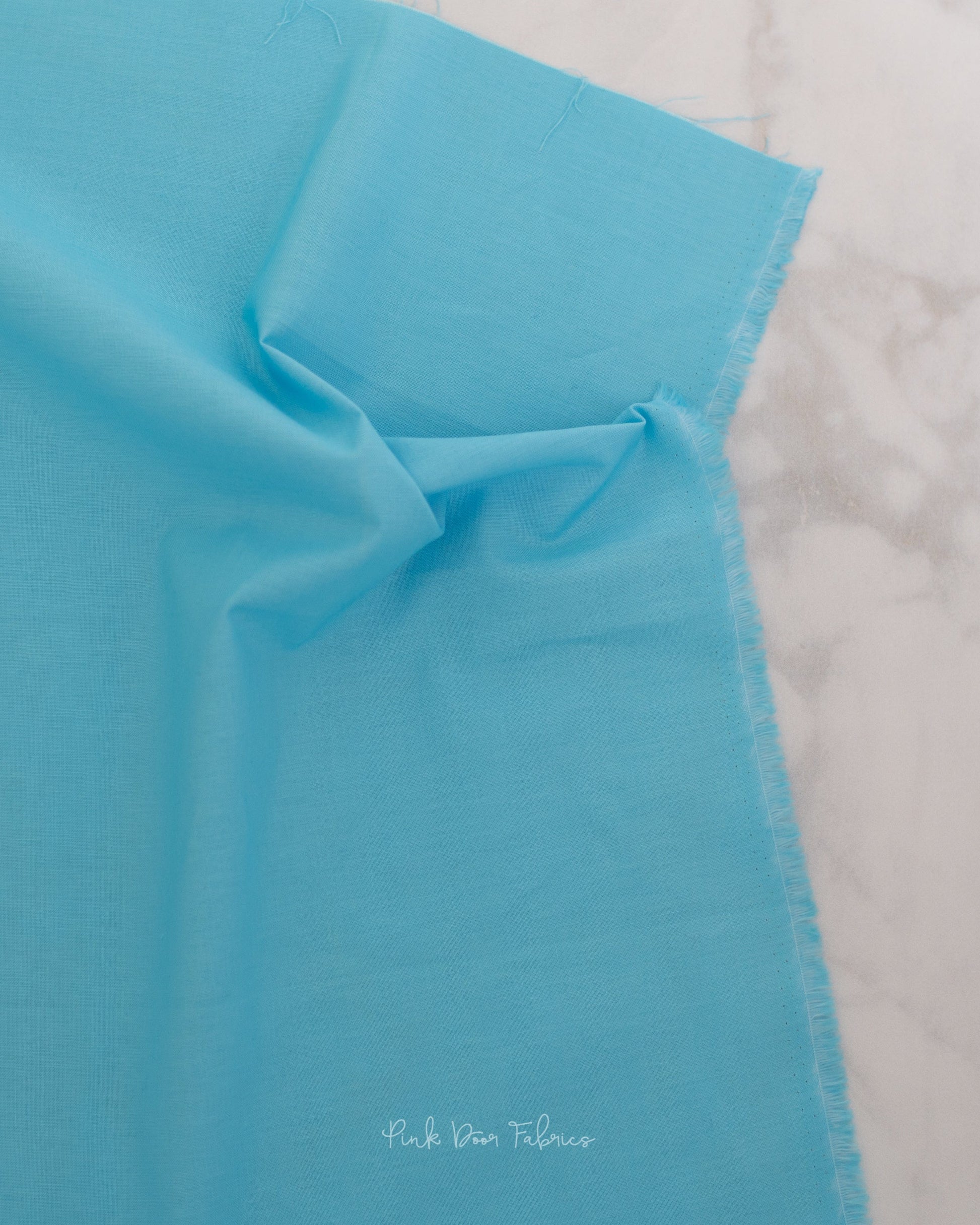 Cotton quilting fabric pattern called 'Solid in Cerulean'. Part of the 'True Colors' fabric collection. Designed by Tula Pink for fabric company Free Spirit Fabrics. SKU: CSFSESS.CERULEAN. 44-45 inch width.