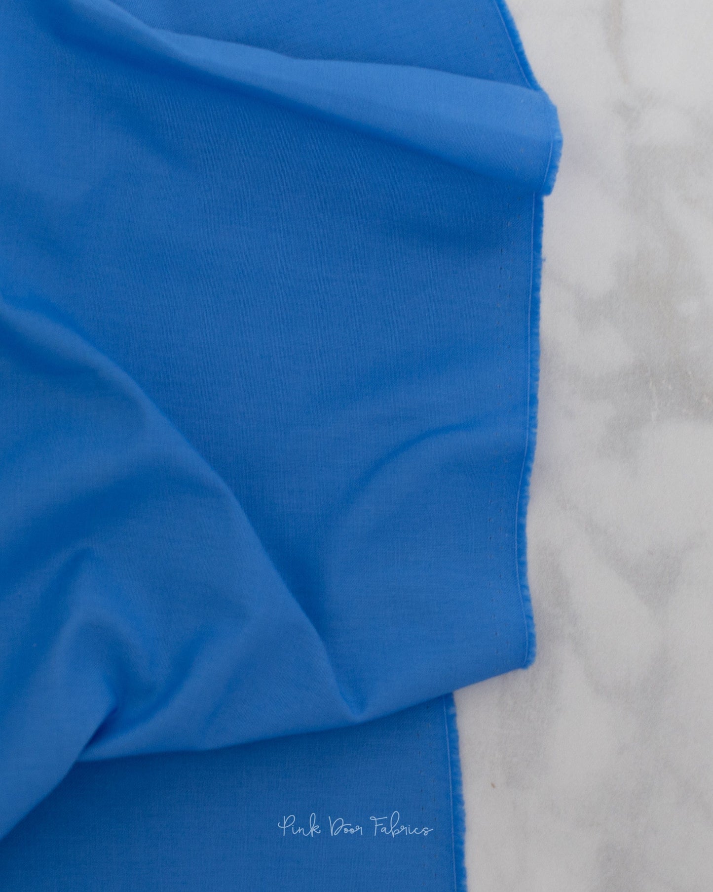 Cotton quilting fabric pattern called 'Solid in Cornflower'. Part of the 'True Colors' fabric collection. Designed by Tula Pink for fabric company Free Spirit Fabrics. SKU: CSFSESS.CORNFLOWER. 44-45 inch width.