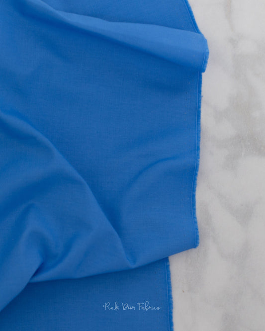Cotton quilting fabric pattern called 'Solid in Cornflower'. Part of the 'True Colors' fabric collection. Designed by Tula Pink for fabric company Free Spirit Fabrics. SKU: CSFSESS.CORNFLOWER. 44-45 inch width.