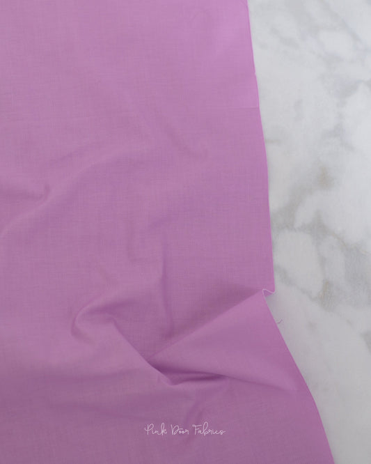 Cotton quilting fabric pattern called 'Solid in Freesia'. Part of the 'True Colors' fabric collection. Designed by Tula Pink for fabric company Free Spirit Fabrics. SKU: CSFSESS.FREESIA. 44-45 inch width.