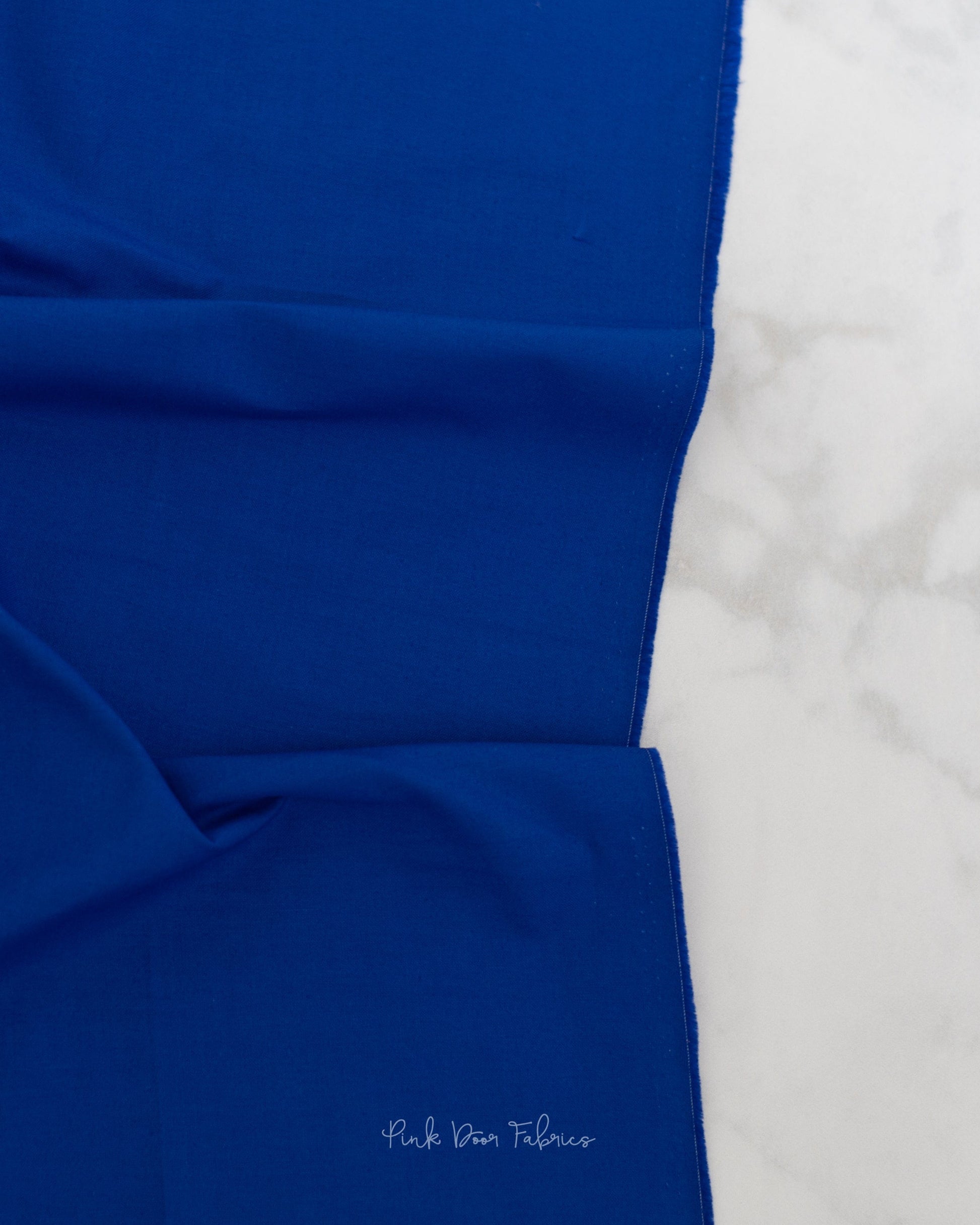Cotton quilting fabric pattern called 'Solid in Sapphire'. Part of the 'True Colors' fabric collection. Designed by Tula Pink for fabric company Free Spirit Fabrics. SKU: CSFSESS.SAPPHIRE. 44-45 inch width.