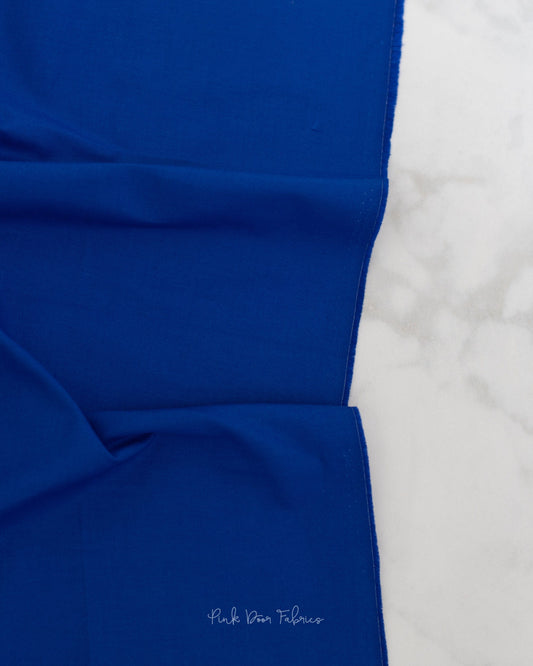 Cotton quilting fabric pattern called 'Solid in Sapphire'. Part of the 'True Colors' fabric collection. Designed by Tula Pink for fabric company Free Spirit Fabrics. SKU: CSFSESS.SAPPHIRE. 44-45 inch width.