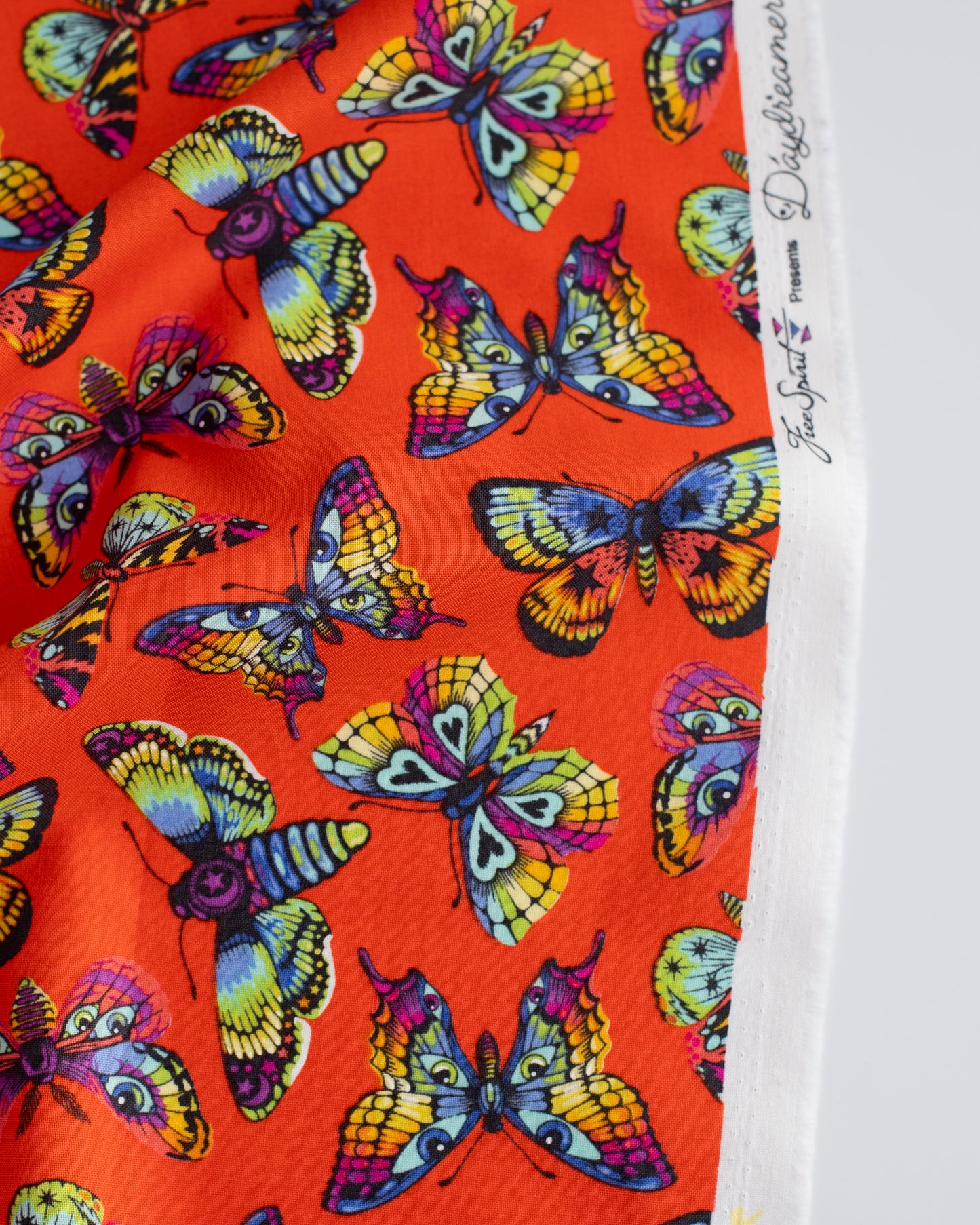 Cotton quilting fabric pattern called 'Butterfly Kisses in Papaya'. Part of the 'Daydreamer' fabric collection. Designed by Tula Pink for fabric company Free Spirit Fabrics. SKU: PWTP172.PAPAYA. 44-45 inch width.