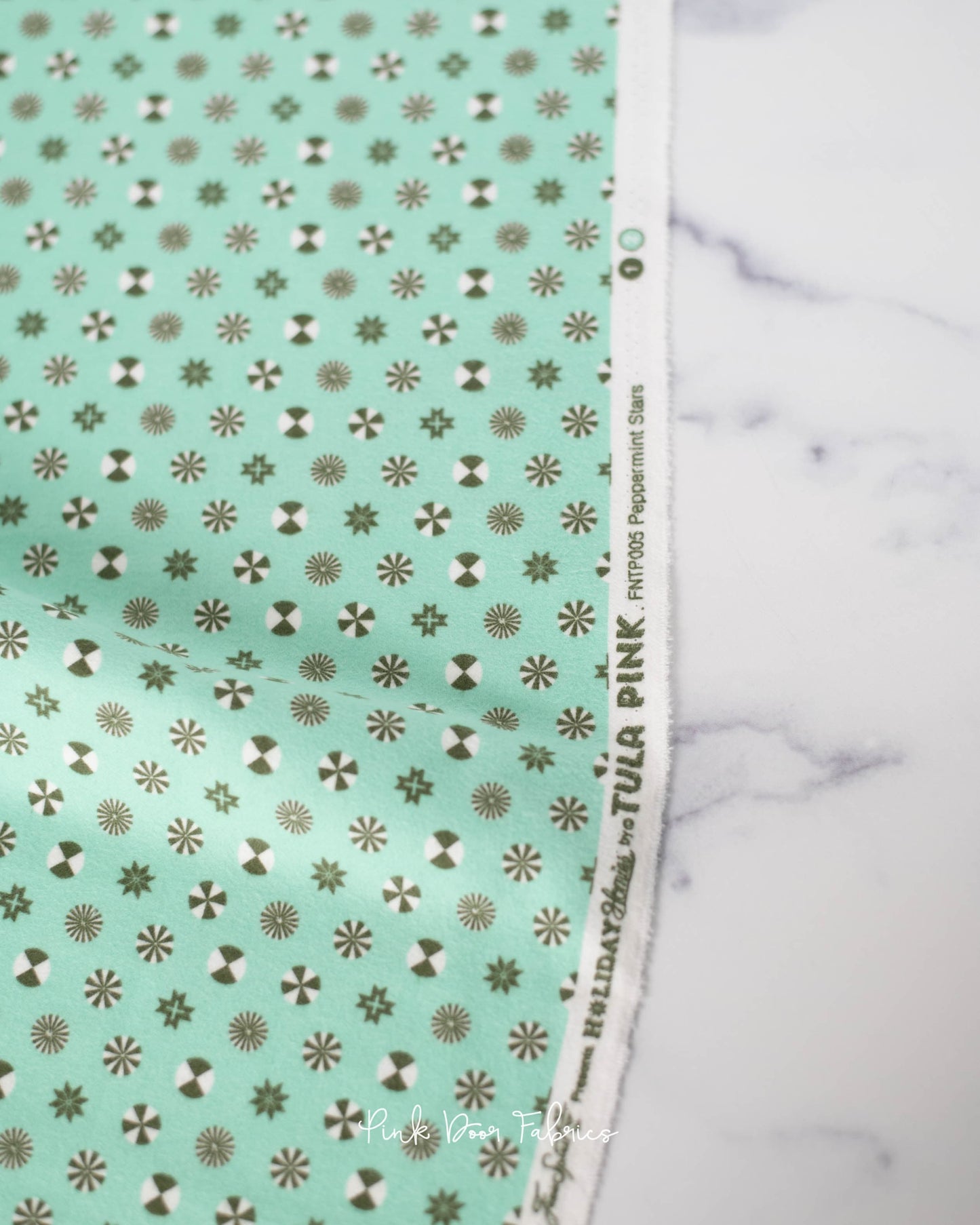 Cotton flannel quilting fabric pattern called 'Peppermint Stars in Pine Fresh'. Part of the 'Holiday Homies flannel' fabric collection. Designed by Tula Pink for the Free Spirit Fabrics fabric company. SKU: FNTP005.PINEFRESH. 44-45 inch width.