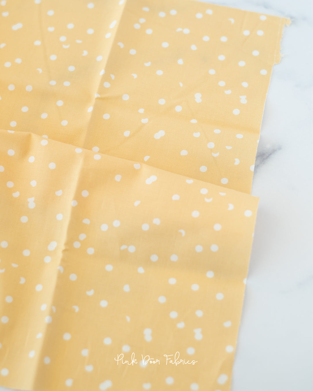 Cotton quilting fabric pattern called 'Dots in Butternut'. Part of the 'Hole Punch Dots' fabric collection. Designed by Ruby Star Society for fabric company Moda Fabrics. SKU: RS3025 25. 44-45 inch width.