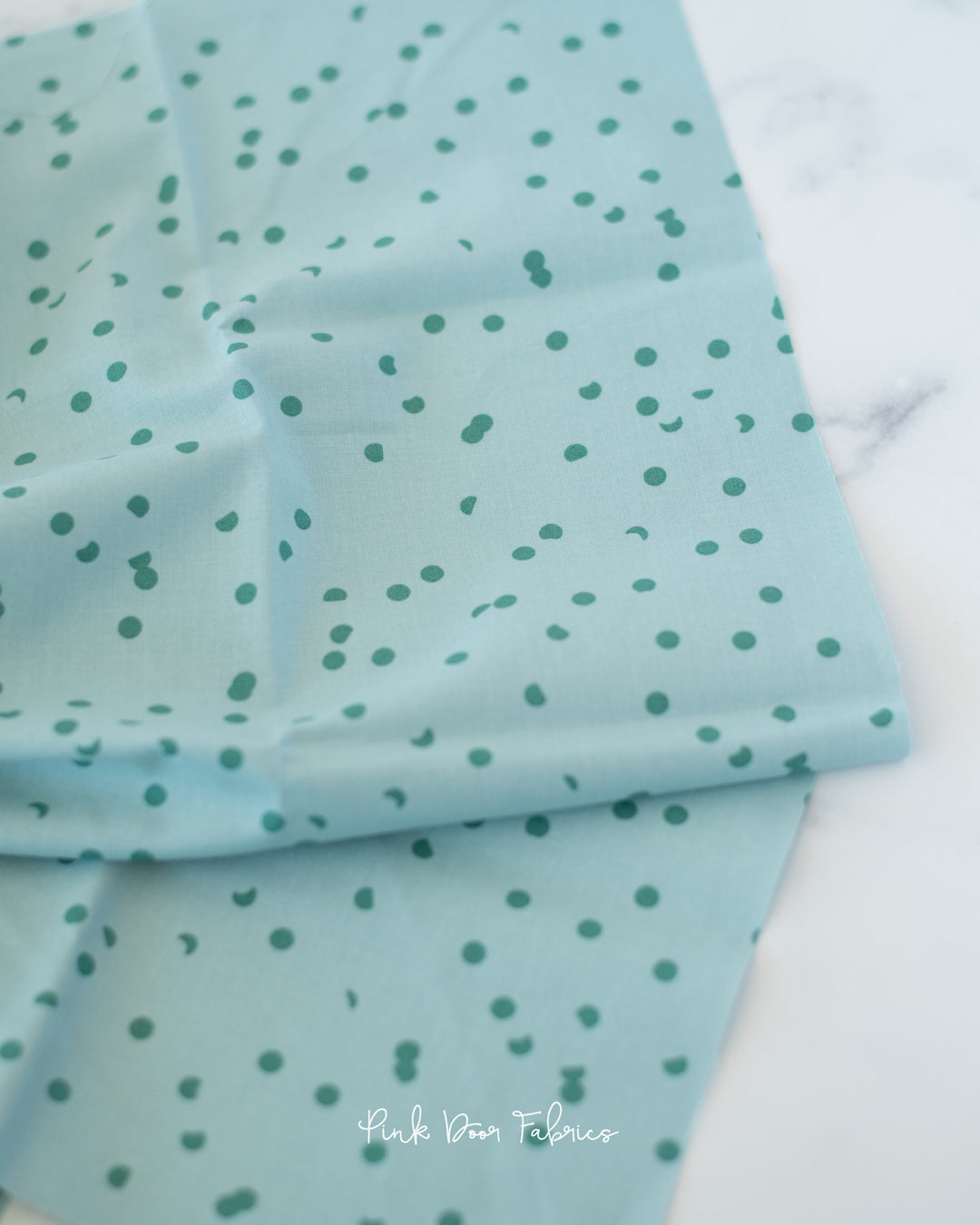 Cotton quilting fabric pattern called 'Dots in Polar'. Part of the 'Hole Punch Dots' fabric collection. Designed by Ruby Star Society for fabric company Moda Fabrics. SKU: RS3025 22. 44-45 inch width.