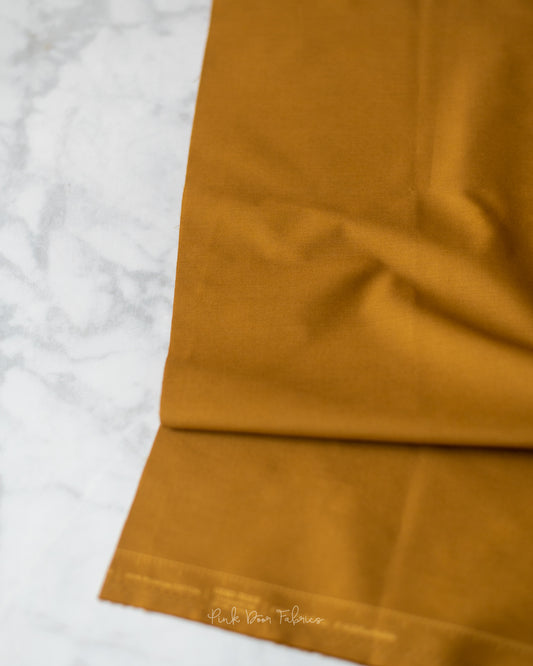 Cotton quilting fabric pattern called 'Golden Bronze'. Part of the 'Pure Solids' fabric collection. Designed by Art Gallery Fabrics for fabric company Art Gallery Fabrics. SKU: PE-504. 44-45 inch width.