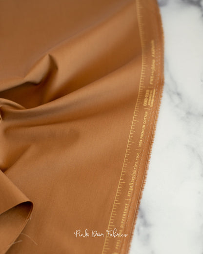 Cotton quilting fabric pattern called 'English Toffee'. Part of the 'Pure Solids' fabric collection. Designed by Art Gallery Fabrics for fabric company Art Gallery Fabrics. SKU: PE-525. 44-45 inch width.