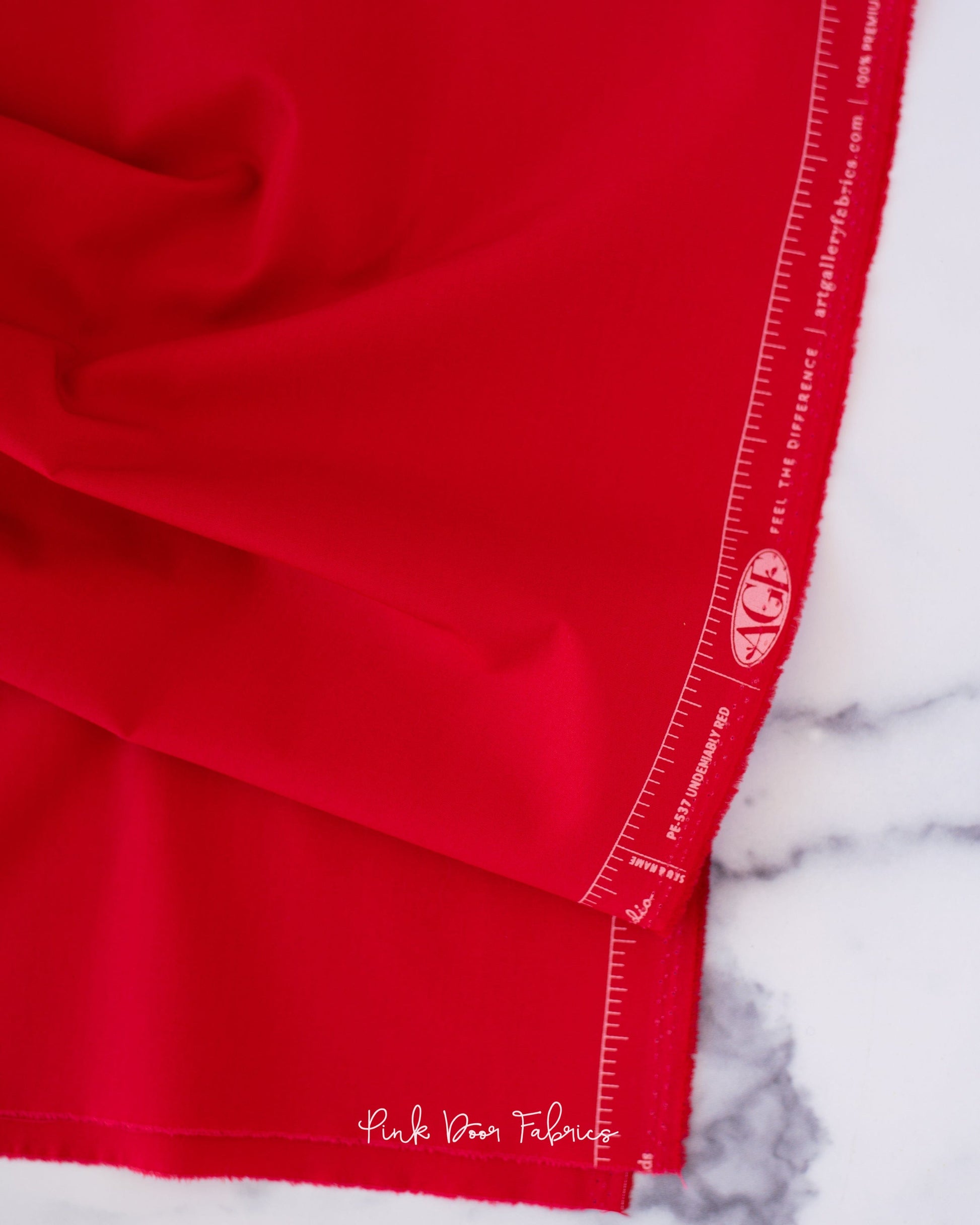 Cotton quilting fabric pattern called 'Undeniably Red'. Part of the 'Pure Solids' fabric collection. Designed by Art Gallery Fabrics for fabric company Art Gallery Fabrics. SKU: PE-537. 44-45 inch width.