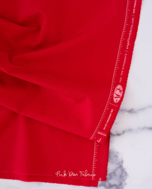 Cotton quilting fabric pattern called 'Undeniably Red'. Part of the 'Pure Solids' fabric collection. Designed by Art Gallery Fabrics for fabric company Art Gallery Fabrics. SKU: PE-537. 44-45 inch width.