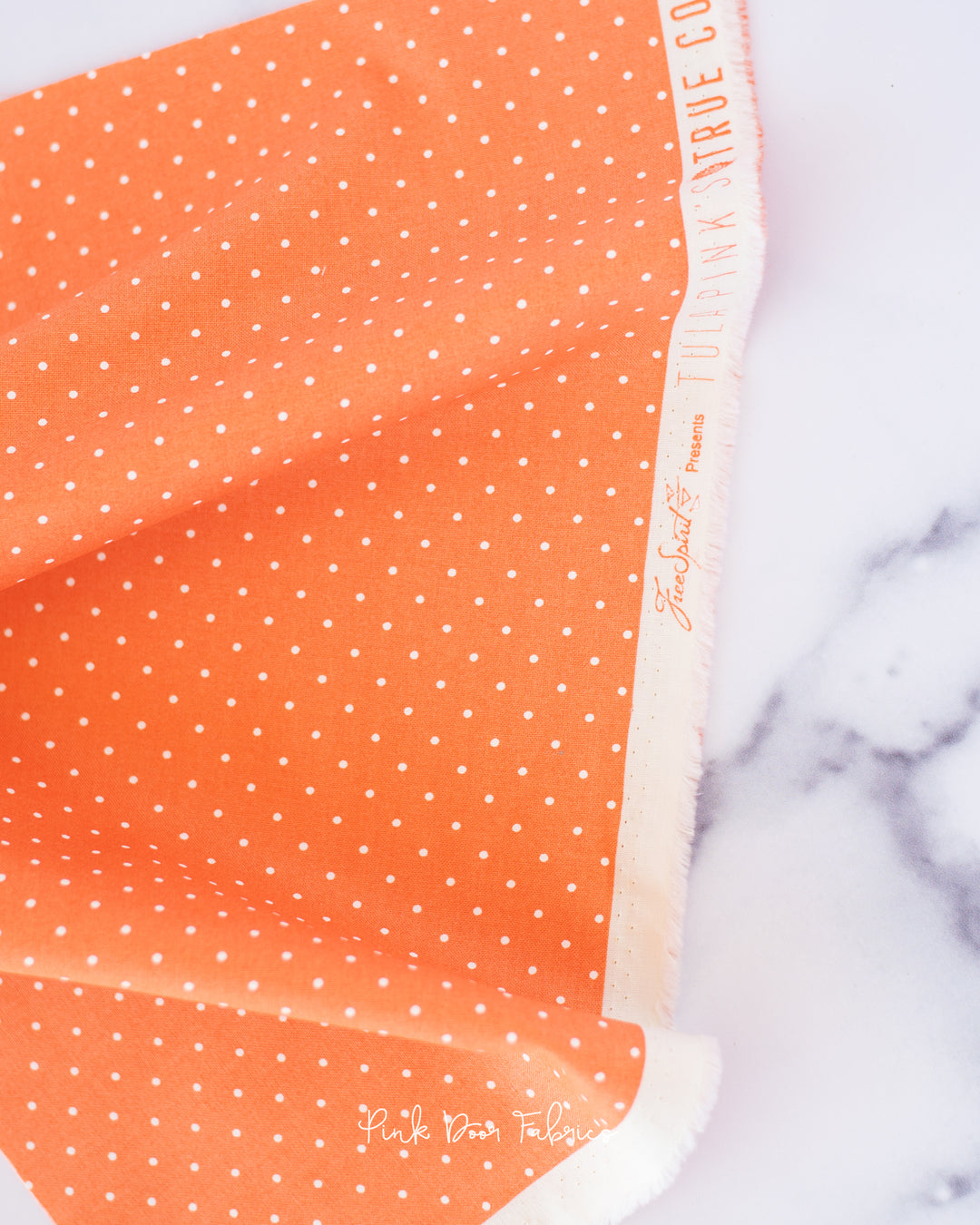 Cotton quilting fabric pattern called 'Tiny Dots in Peachy'. Part of the 'True Colors' fabric collection. Designed by Tula Pink for fabric company Free Spirit Fabrics. SKU: PWTP185.PEACHY. 44-45 inch width.