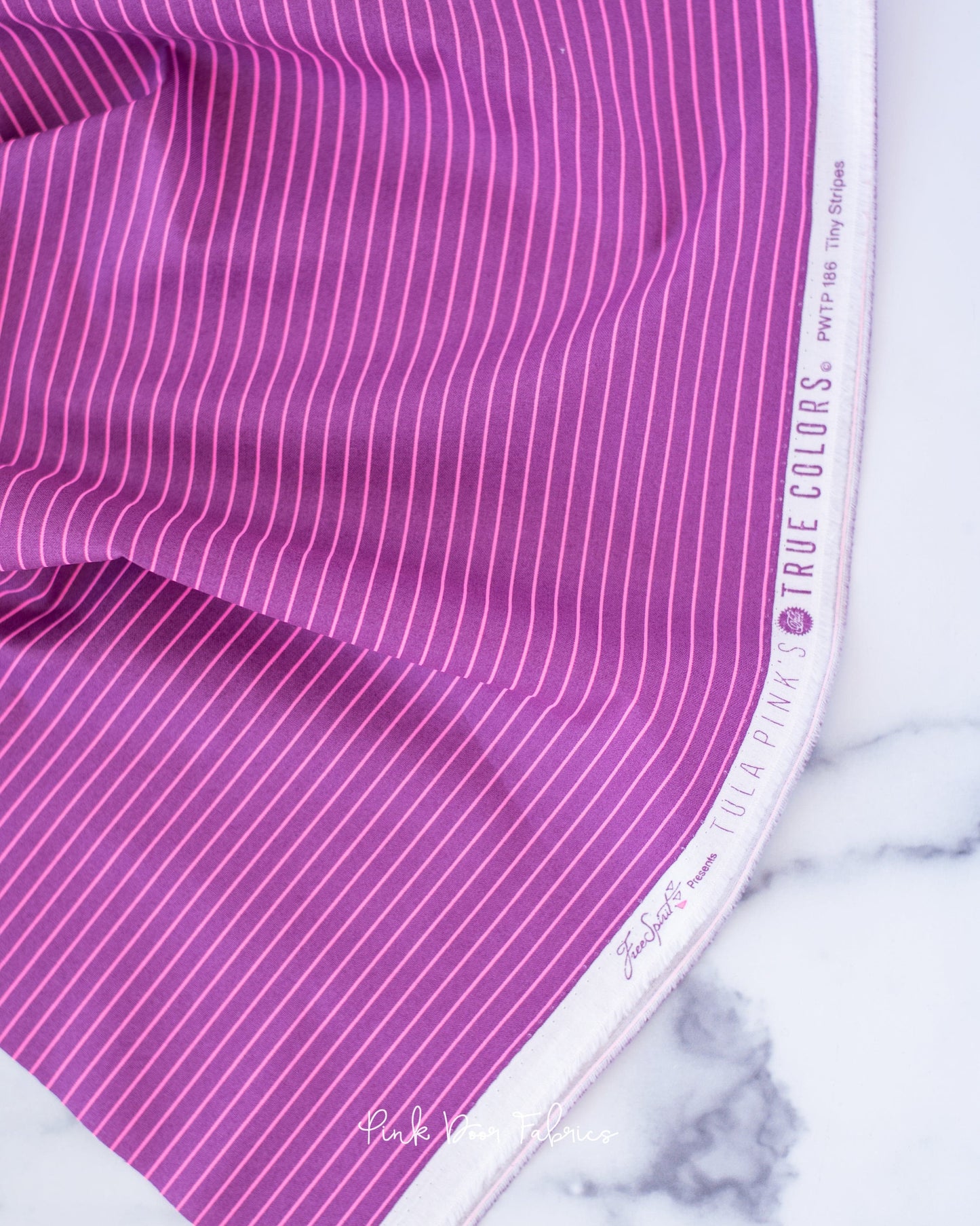 Cotton quilting fabric pattern called 'Tiny Stripes in Aster'. Part of the 'True Colors' fabric collection. Designed by Tula Pink for fabric company Free Spirit Fabrics. SKU: PWTP186.ASTER. 44-45 inch width.