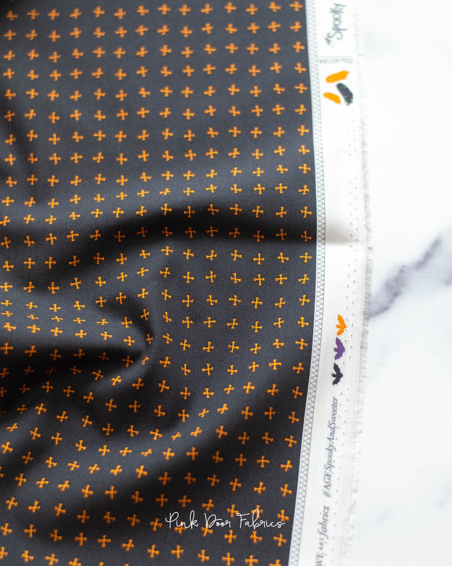 Cotton quilting fabric pattern called 'Crossed Bones in Night'. Part of the 'Spooky 'N Sweeter' fabric collection. Designed by AGF Studio for fabric company Art Gallery Fabrics. SKU: SNS-13016. 44-45 inch width.