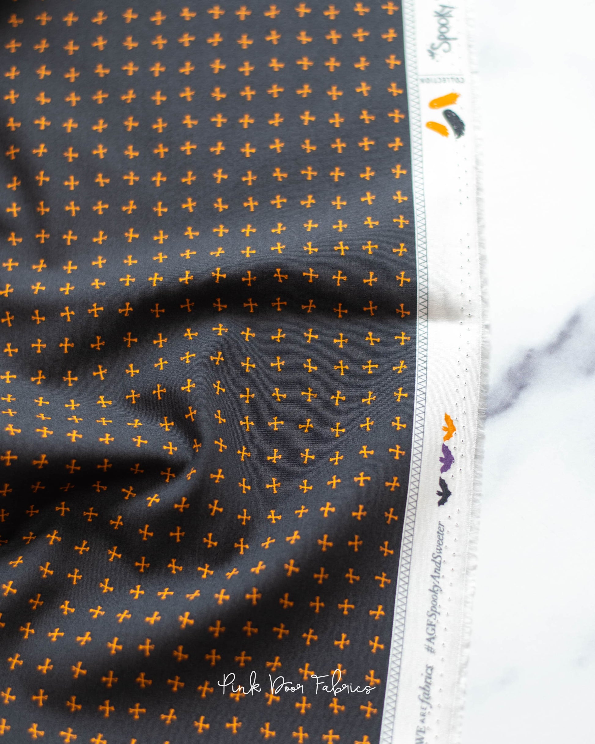 Cotton quilting fabric pattern called 'Crossed Bones in Night'. Part of the 'Spooky 'N Sweeter' fabric collection. Designed by AGF Studio for fabric company Art Gallery Fabrics. SKU: SNS-13016. 44-45 inch width.