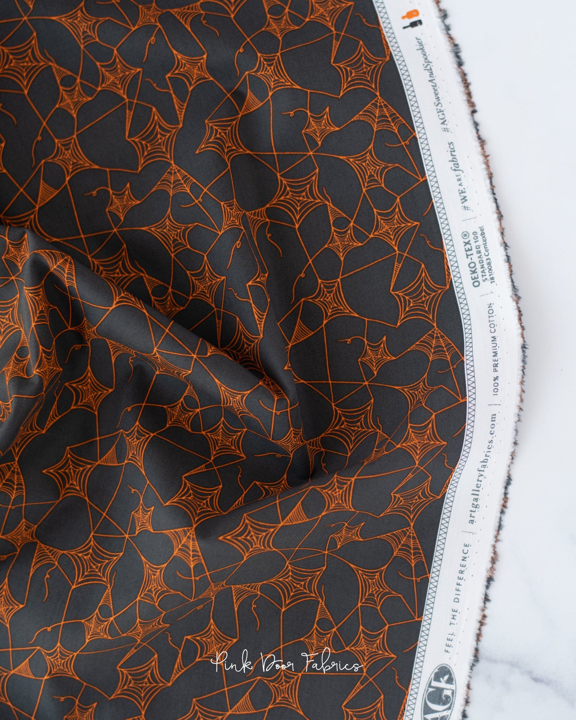 Cotton quilting fabric pattern called 'Web of Scares in Caramel'. Part of the 'Sweet 'N Spookier' fabric collection. Designed by AGF Studio for fabric company Art Gallery Fabrics. SKU: SNS-13030. 44-45 inch width.