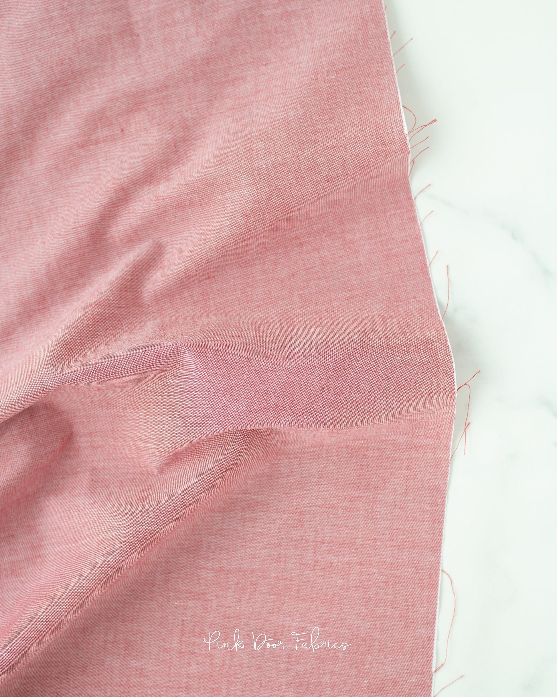 Chambray quilting fabric pattern called 'Red'. Part of the 'Chambray Solids' fabric collection. Designed by Tilda Fabrics for the Tilda Fabrics fabric company. SKU: 160001. 44-45 inch width.