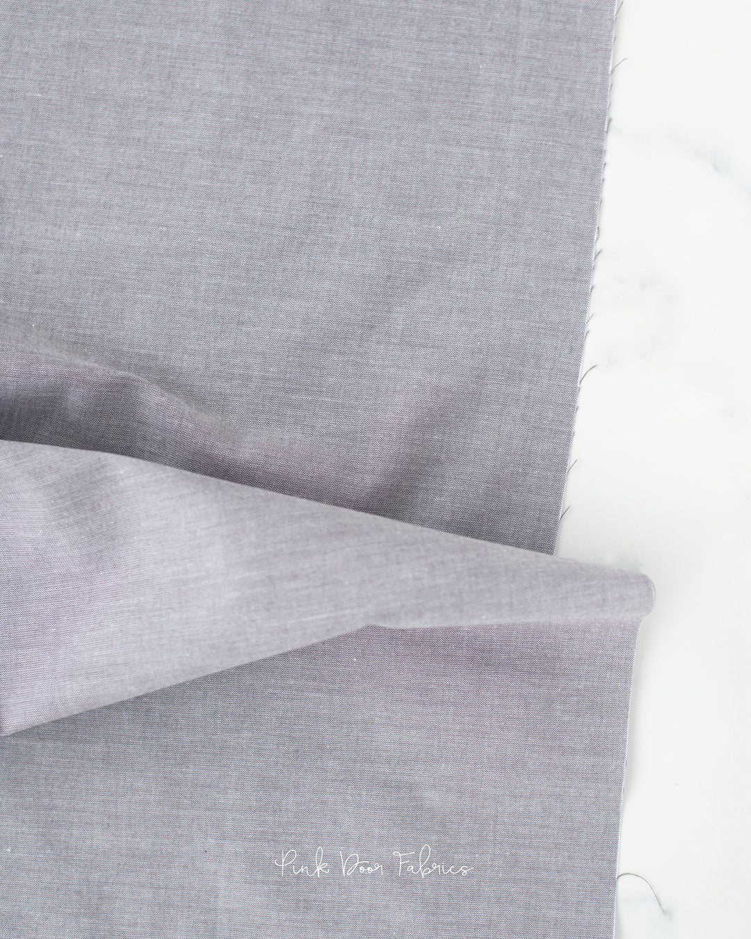 Chambray quilting fabric pattern called 'Grey'. Part of the 'Chambray Solids' fabric collection. Designed by Tilda Fabrics for the Tilda Fabrics fabric company. SKU: 160006. 44-45 inch width.