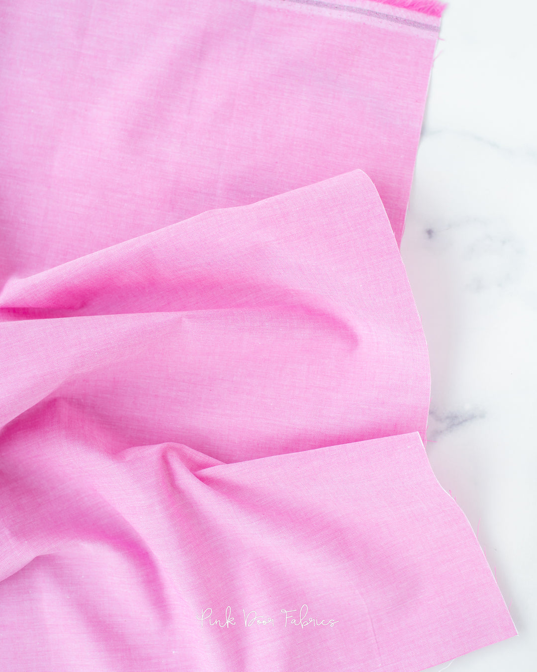 Chambray quilting fabric pattern called 'Cerise'. Part of the 'Chambray Solids' fabric collection. Designed by Tilda Fabrics for the Tilda Fabrics fabric company. SKU: 160013. 44-45 inch width.