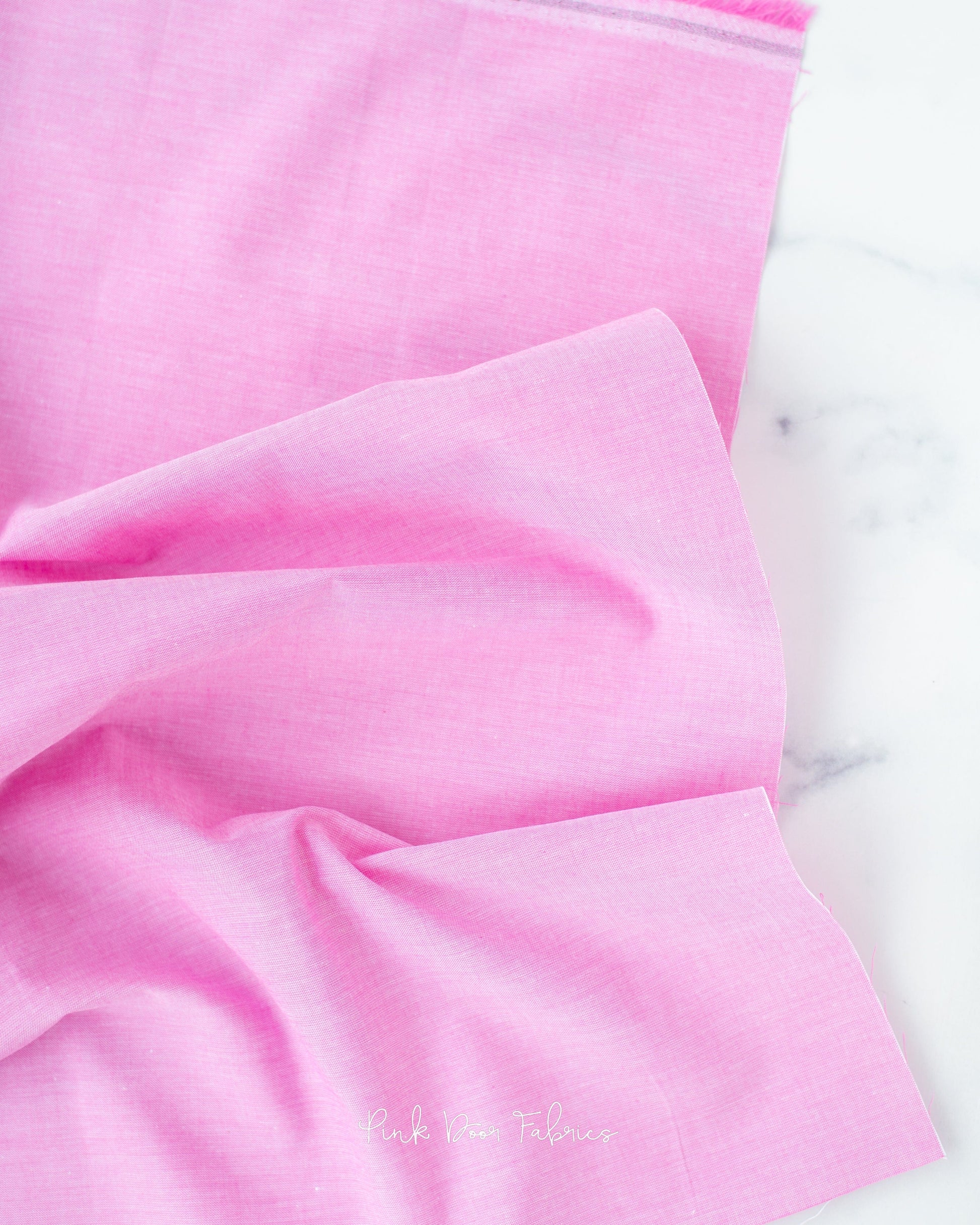 Chambray quilting fabric pattern called 'Cerise'. Part of the 'Chambray Solids' fabric collection. Designed by Tilda Fabrics for the Tilda Fabrics fabric company. SKU: 160013. 44-45 inch width.